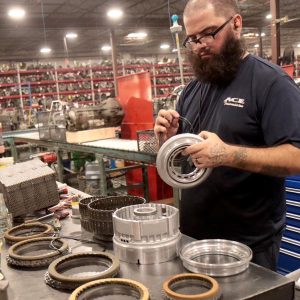 A man assembles a remanufactured transmission in a factory.